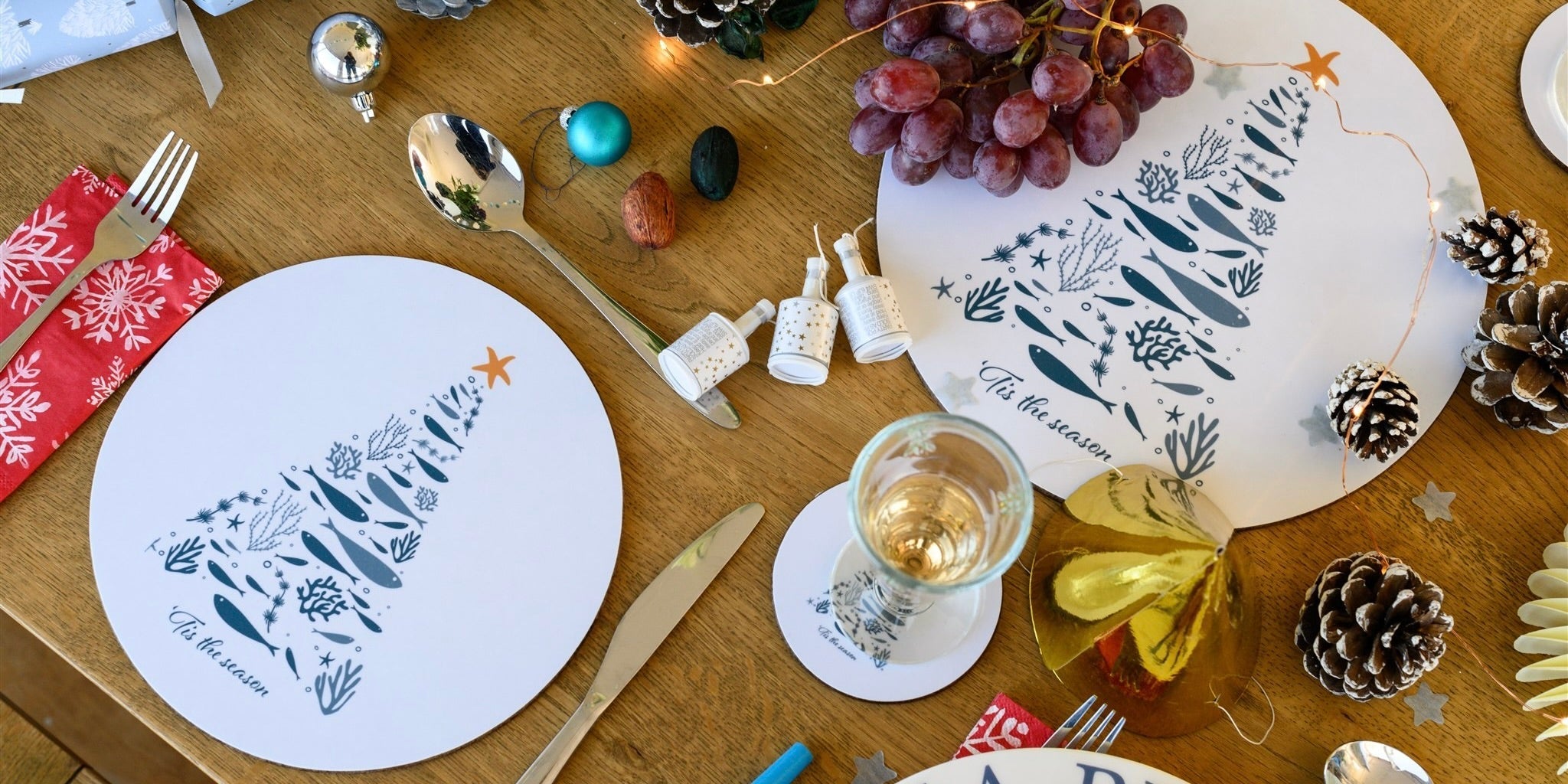 Christmas table set with blue & white designed, Christmas trees on wipe clean, cork backed place mats & coasters.